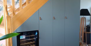 Réalisations menuisier poseur Les sens du Bois Agencement sous escalier réalisé en panneau mélaminé bleu.