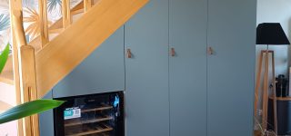 Réalisations menuisier poseur Les sens du Bois Agencement sous escalier réalisé en panneau mélaminé bleu.